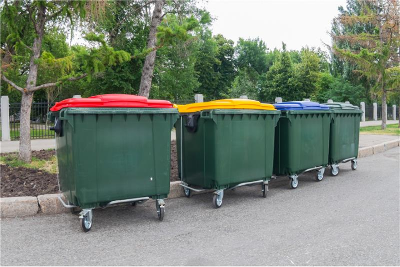 Large business waste bins in street that are for separated recyclable rubbish